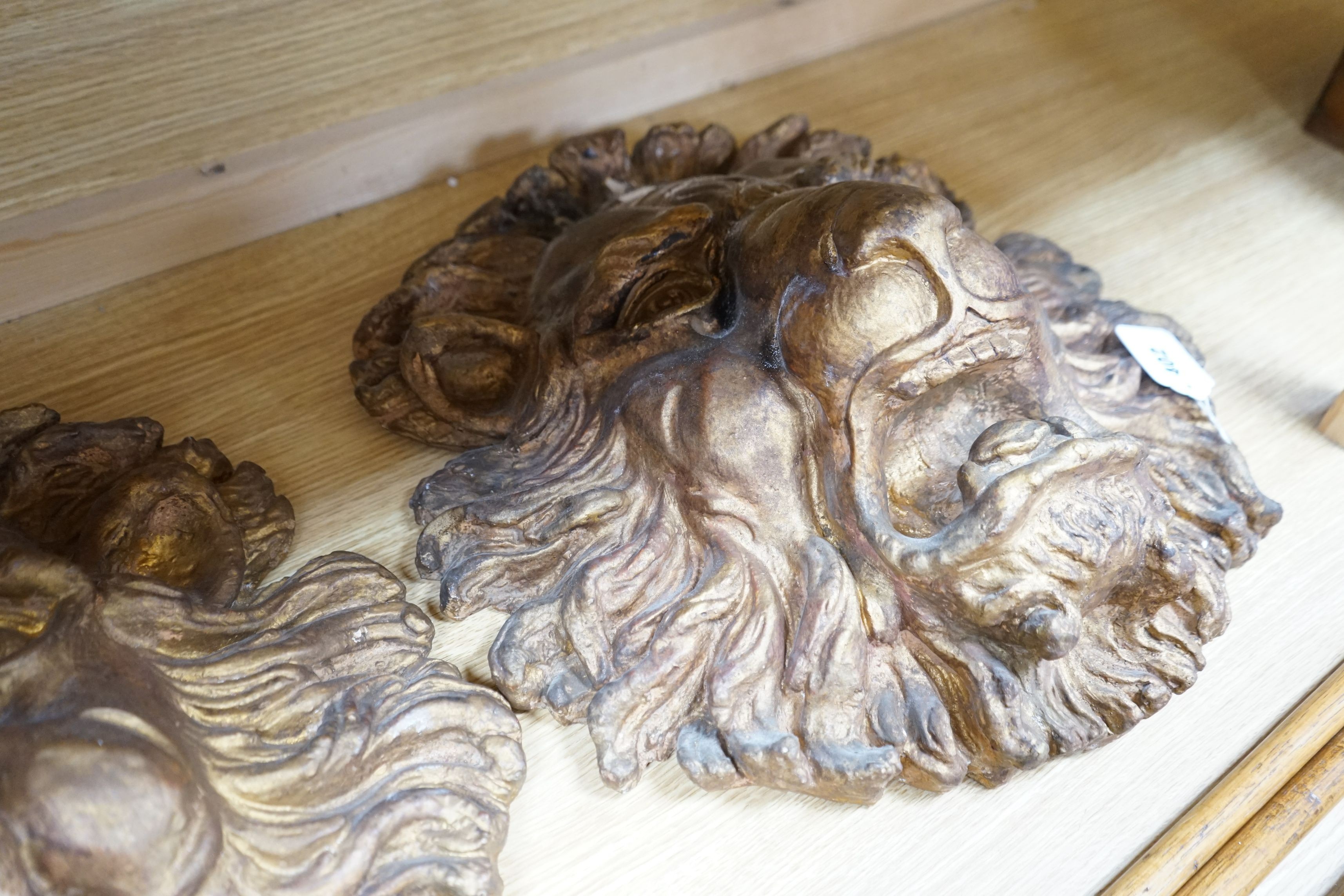 A pair of large decorative gilt plaster lion masks, 42cm